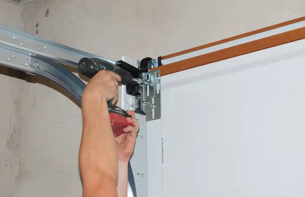 Technician adjusting garage door track and roller hardware