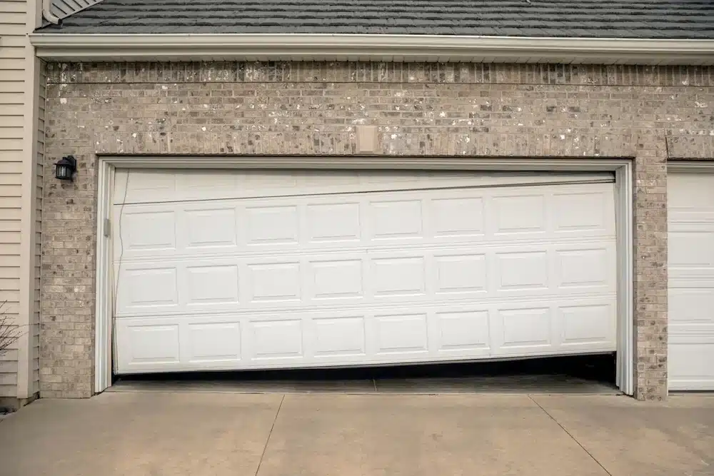 Garage door sitting off track and partially open on a residential home