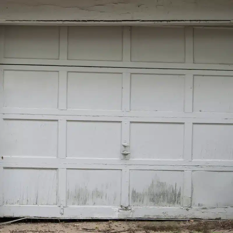 Worn and neglected garage door showing signs of damage and deterioration