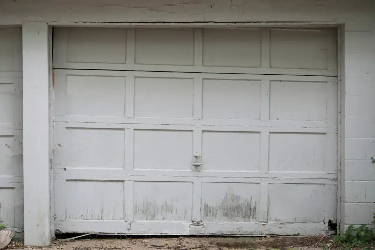Worn and neglected garage door showing signs of damage and deterioration