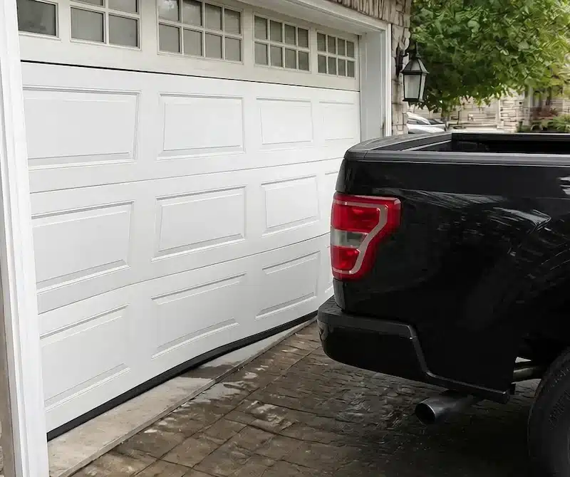 Garage door bowed after being backed into by a pickup truck