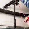 Hand pulling the manual release cord on a garage door opener trolley